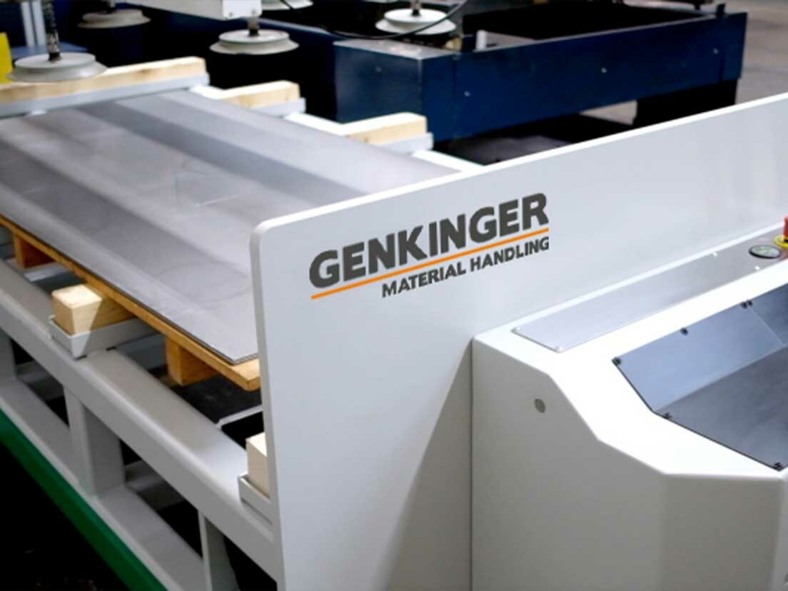 Genkinger Niederhub-Transportwagen positioniert Blechtafeln an einer Laserschneidanlage.
