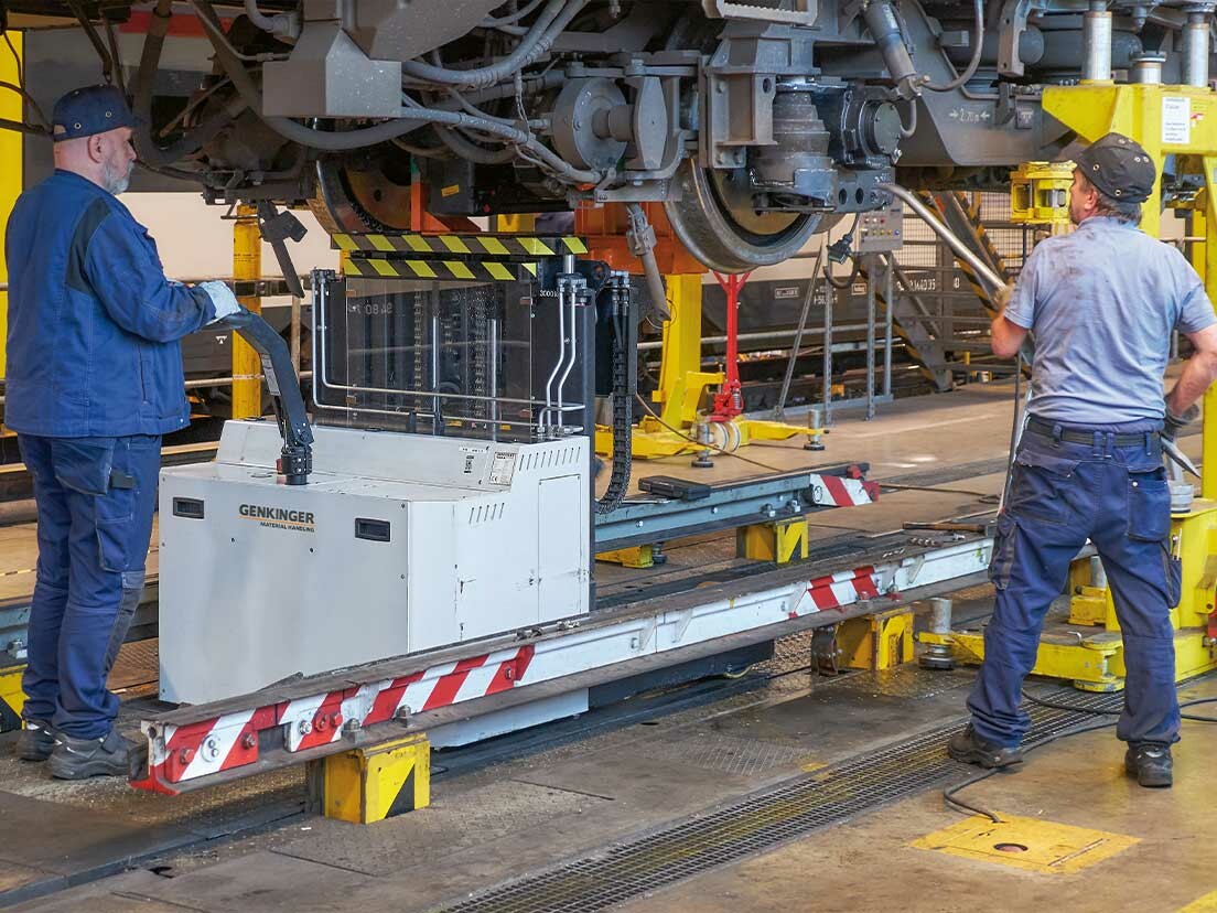 Genkinger Flurförderzeug beim Radsatzwechsel an einer S-Bahn mit zwei Mitarbeitern bei der Montage