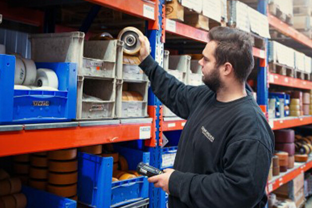 Fachkraft für Logistik und Materialwirtschaft Azubi räumt Materialien in ein Regal und arbeitet an der Lagerorganisation bei Genkinger.