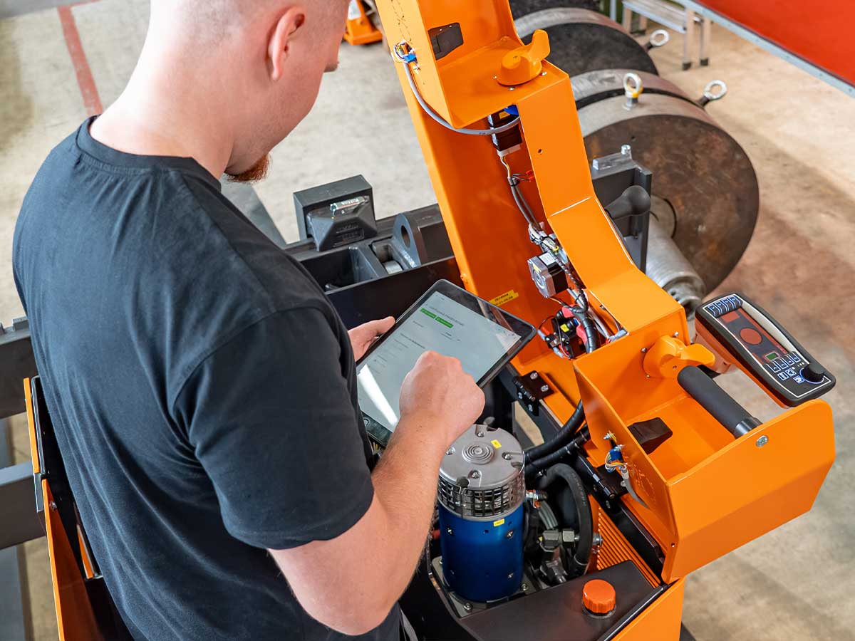 Servicetechniker von Genkinger nutzt die digitale Geräteakte auf einem iPad für Wartung, Service und Dokumentation eines Flurförderfahrzeugs.