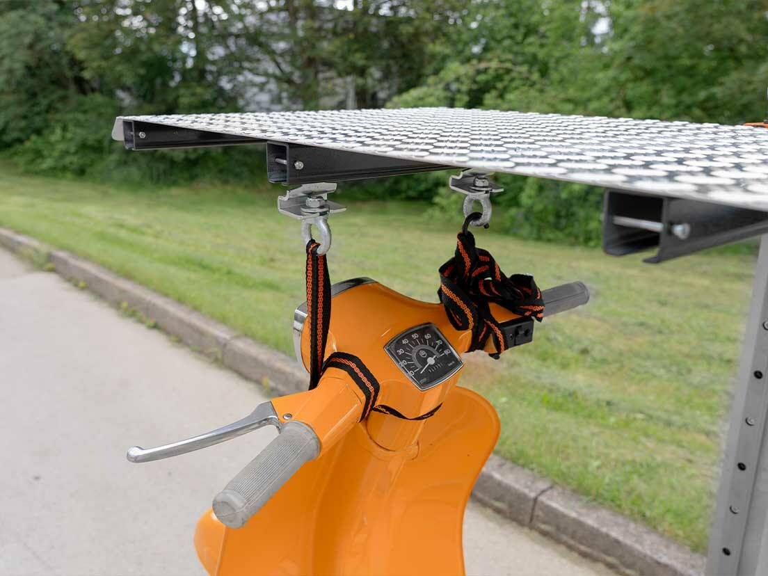 Last mit Spanngurten unter der Plattform des Bike Lifters gesichert